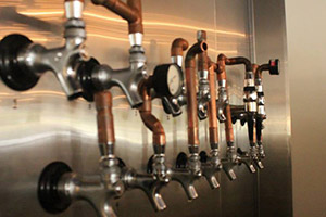 The stainless steel wall of beer taps at Lupulo